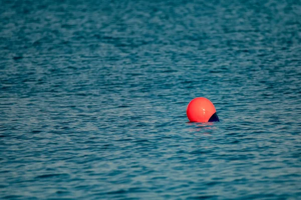 Rode boei op de donkere golvende blauwe zee — Stockfoto