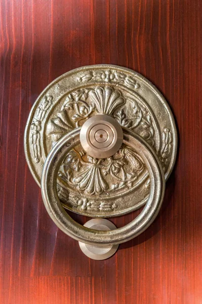Pomo de bronce redondo antiguo con golpeador en la puerta de madera — Foto de Stock