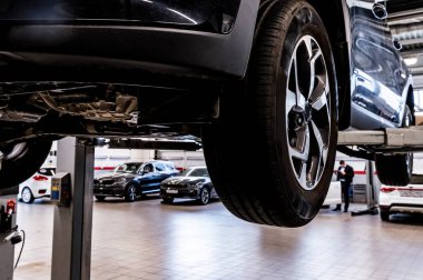 Araba tamircisi servis istasyonunda arabayı kontrol ediyor..