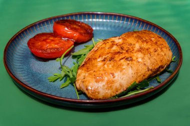 Kemiksiz tavuk göğsü ve kızarmış domatesle yakın görüş yemeği..