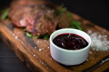 Orta pişmiş dana eti, kaba tuz, baharat ve roka yapraklı kiraz sosu.