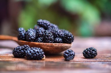 Masadaki tahta kaşıkla taze dut meyvesini kapat.