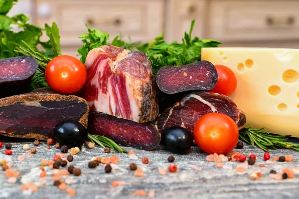 Close up of assorted dry-cured meat on the wooden background