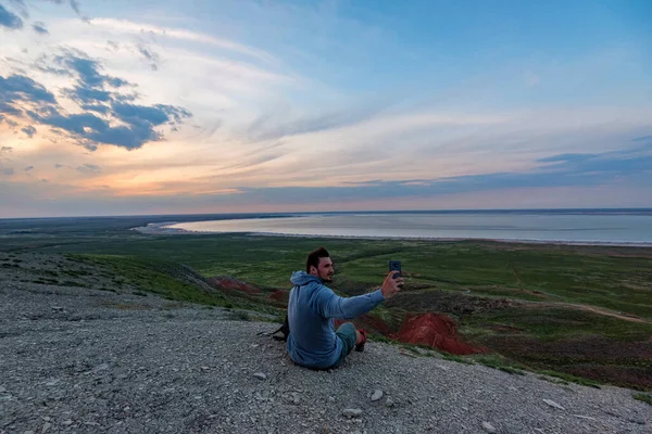 Visão traseira jovem caminhante masculino olha para o mar e horizonte — Fotografia de Stock