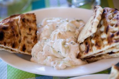 Yararları dilimleri tzatziki sos ile beyaz bir plaka üzerinde