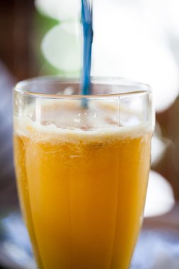 Bir saman ile bir bardak taze portakal suyu