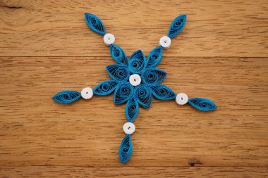 Teknik bir ahşap yüzeyde quilling ile yapılan kağıt kar taneleri