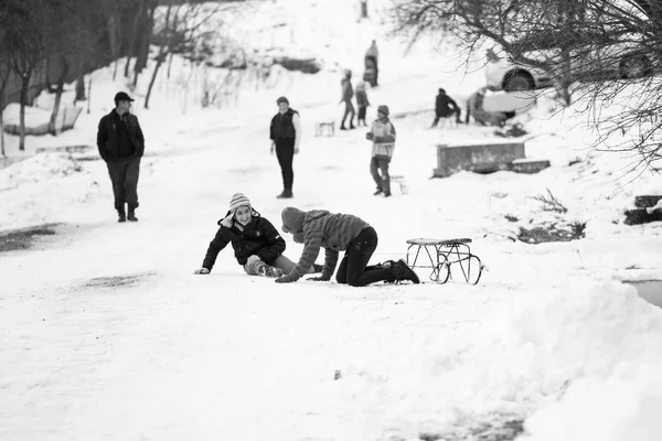 23. 12. 2012. RESCA, ROMANIA. Small southern romanian village. Scenes from a moody winter with children playing with sledges and enjoying the snow — Stock Photo, Image