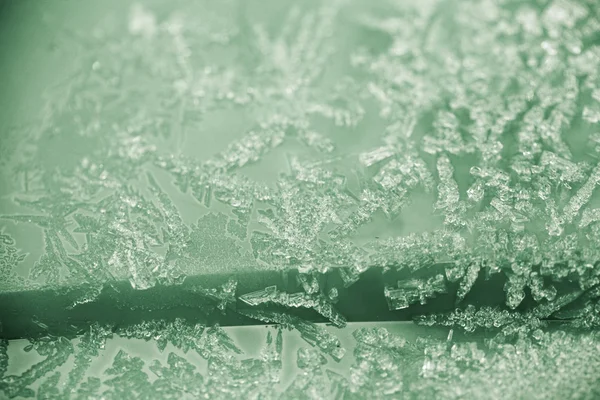 Pequenos pedaços de gelo em uma superfície de plástico, fundo de inverno e textura — Fotografia de Stock