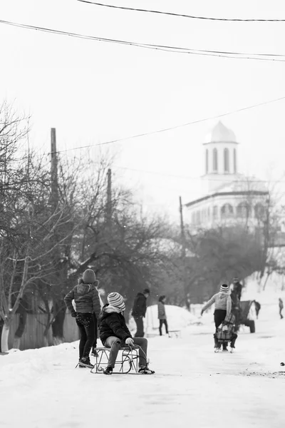 23. 12。2012 年 Resca、ルーマニア。小さな南部のルーマニアの村。子供たち用そりで遊んで、雪を楽しんでいると不機嫌そうな冬からのシーン — ストック写真