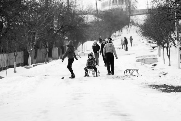 23. 12. Em 2012. RESCA, ROMANIA. Pequena aldeia romena do sul. Cenas de um inverno temperamental com crianças brincando com trenós e curtindo a neve — Fotografia de Stock