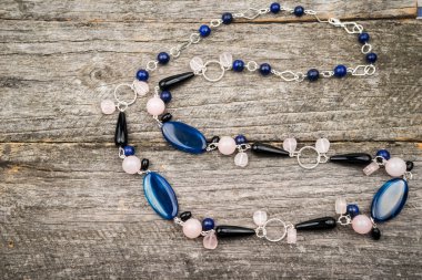 Gümüş renkli değerli taşlar bir ahşap yüzey üzerinde mücevherlerle