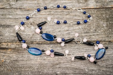 Gümüş renkli değerli taşlar bir ahşap yüzey üzerinde mücevherlerle