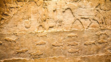 29. 07. 2015, Londra, İngiltere, British Museum - Asur duvarından arka planda Mısır binaları gösteren ayrıntılar. Ön planda, Nubia'lı mahkum tüy şapka giymek.
