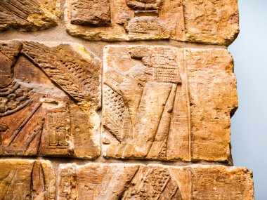 29. 07. 2015, Londra, İngiltere, British Museum - Asur duvarından arka planda Mısır binaları gösteren ayrıntılar. Ön planda, Nubia'lı mahkum tüy şapka giymek.