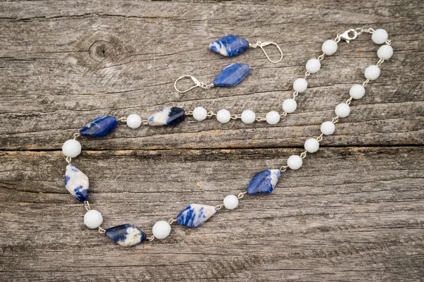Stříbrné šperky s barevnými drahými kameny na dřevěný podklad — Stock fotografie