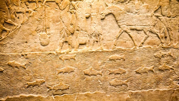 29. 07. 2015-ig, London, Egyesült Királyság, British Museum - részletek az asszír fal mutatja az egyiptomi épületek a háttérben. Az előtérben a núbiai foglyok viselni tollas fejdísz — Stock Fotó