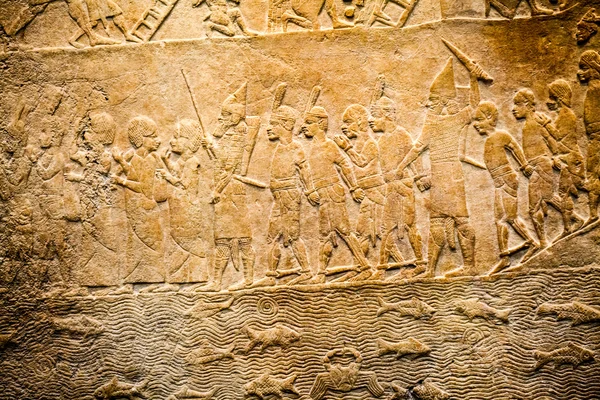 29. 07. 2015, LONDRA, Regno Unito, MUSEO BRITISH - Dettagli dal muro assiro che mostrano edifici egiziani sullo sfondo. In primo piano, i prigionieri nubiani indossano copricapi di piume — Foto Stock