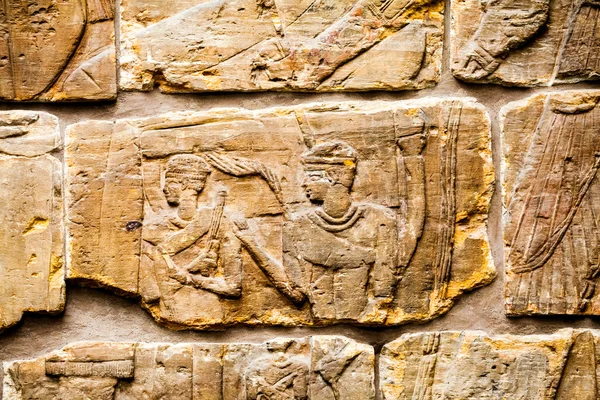 29. 07. 2015, LONDRES, ROYAUME-UNI, MUSÉE BRITANNIQUE - Détails du mur assyrien montrant des bâtiments égyptiens en arrière-plan. Au premier plan, les prisonniers nubiens portent des coiffes de plumes — Photo