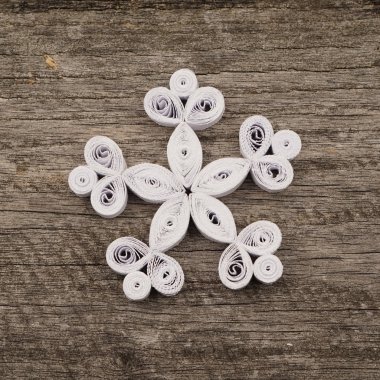 Teknik bir ahşap yüzeyde quilling ile yapılan kağıt kar taneleri