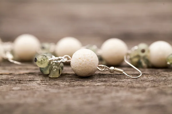 Silver jewels with colorful precious stones on a wooden surface — Stock Photo, Image