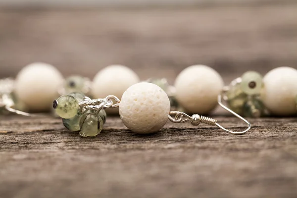 Joyas de plata con piedras preciosas de colores sobre una superficie de madera — Foto de Stock