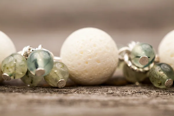 Joyas de plata con piedras preciosas de colores sobre una superficie de madera — Foto de Stock