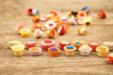 Teknik bir ahşap yüzeyde quilling ile yapılan küçük, renkli kağıt çiçekler
