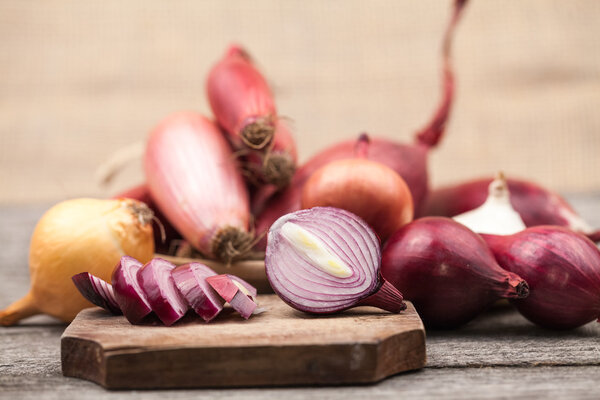 Different types of onions on a wooden surface