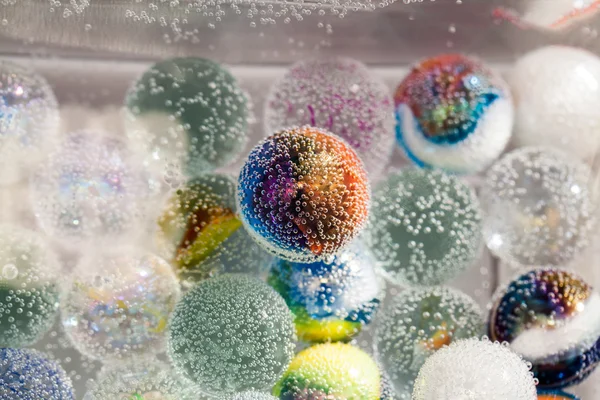 Abstracte onderwater compositie met kleurrijke glazen bollen, bubbels en licht — Stockfoto