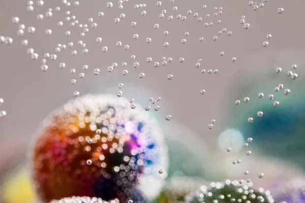 Composição subaquática abstrata com bolas de vidro coloridas, bolhas e luz — Fotografia de Stock