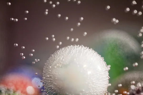 Composición submarina abstracta con bolas de vidrio de colores, burbujas y luz — Foto de Stock