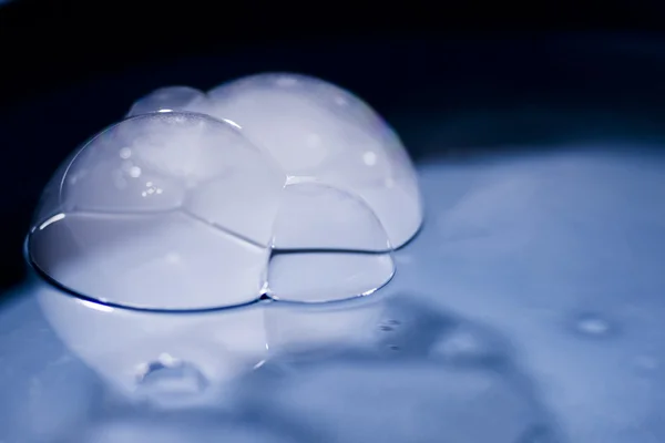 Abstract shot with big soap bubbles on a water surface with smoke inside. Image has grain texture visible on its maximum size — Stock Photo, Image