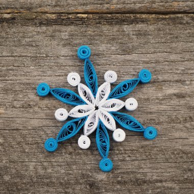 Teknik bir ahşap yüzeyde quilling ile yapılan kağıt kar taneleri