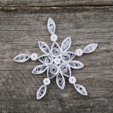 Teknik bir ahşap yüzeyde quilling ile yapılan kağıt kar taneleri