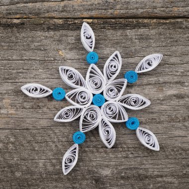 Teknik bir ahşap yüzeyde quilling ile yapılan kağıt kar taneleri