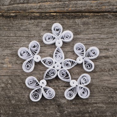 Teknik bir ahşap yüzeyde quilling ile yapılan kağıt kar taneleri