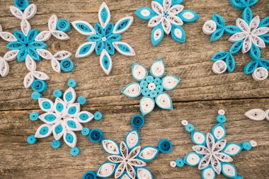 Teknik bir ahşap yüzeyde quilling ile yapılan kağıt kar taneleri