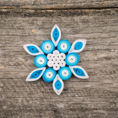 Teknik bir ahşap yüzeyde quilling ile yapılan kağıt kar taneleri