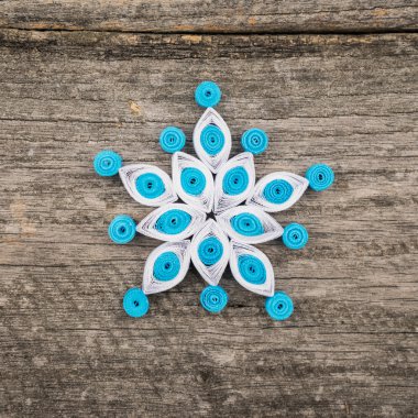 Teknik bir ahşap yüzeyde quilling ile yapılan kağıt kar taneleri