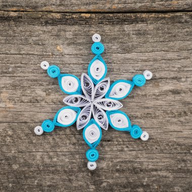Teknik bir ahşap yüzeyde quilling ile yapılan kağıt kar taneleri