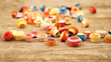 Teknik bir ahşap yüzeyde quilling ile yapılan küçük, renkli kağıt çiçekler