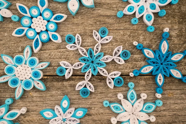 Χαρτί νιφάδες χιονιού γίνεται με quilling τεχνική σε μια ξύλινη επιφάνεια — Φωτογραφία Αρχείου