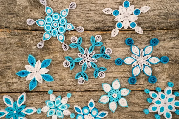 Χαρτί νιφάδες χιονιού γίνεται με quilling τεχνική σε μια ξύλινη επιφάνεια — Φωτογραφία Αρχείου