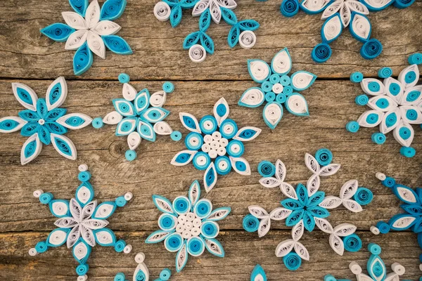 Χαρτί νιφάδες χιονιού γίνεται με quilling τεχνική σε μια ξύλινη επιφάνεια — Φωτογραφία Αρχείου