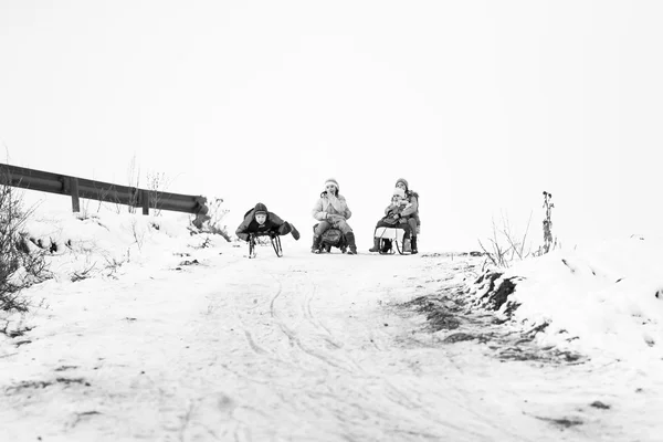 23. 12. Em 2012. RESCA, ROMANIA. Pequena aldeia romena do sul. Cenas de um inverno temperamental com crianças brincando com trenós e curtindo a neve — Fotografia de Stock