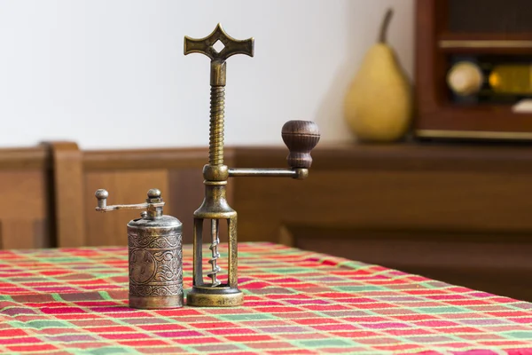 Stilleben komposition med metalliskt peppar kvarn och koppar korkskruv på färgade duk — Stockfoto