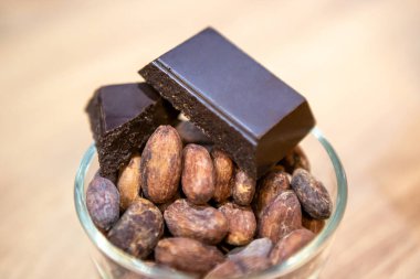Tahta bir masada kakao çekirdeği ve çikolata.