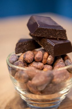 Tahta bir masada kakao çekirdeği ve çikolata.