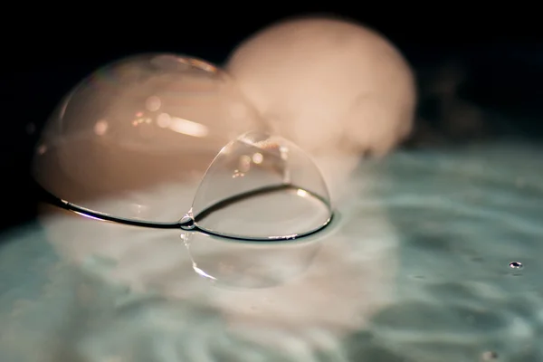 Colpo astratto con grandi bolle di sapone su una superficie d'acqua con fumo all'interno — Foto Stock